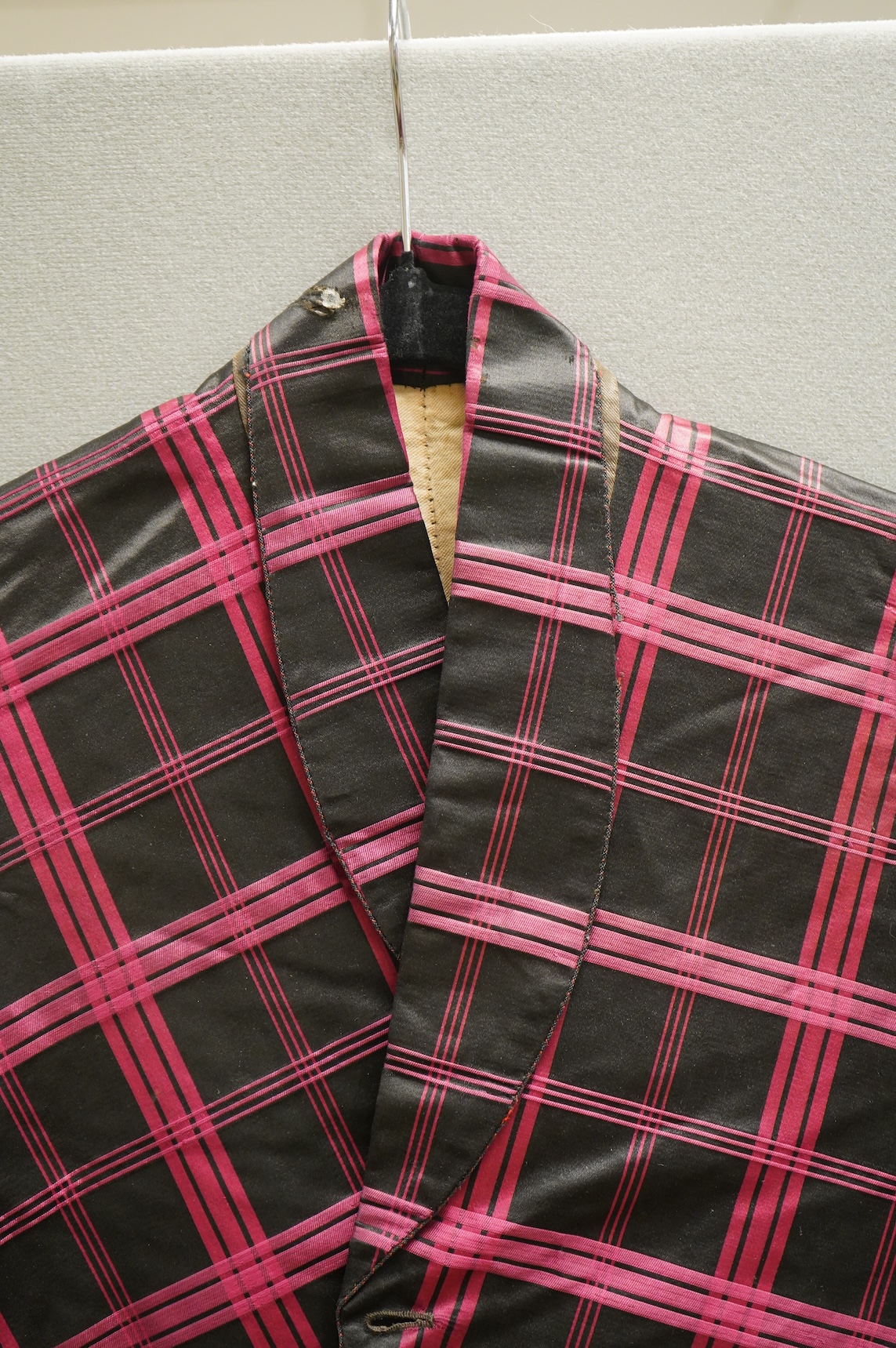 A 19th century gentleman's pink and black silk check waistcoat, with collar and two pockets. Front under arm chest 50cm. Condition - lining stained may need professional cleaning.